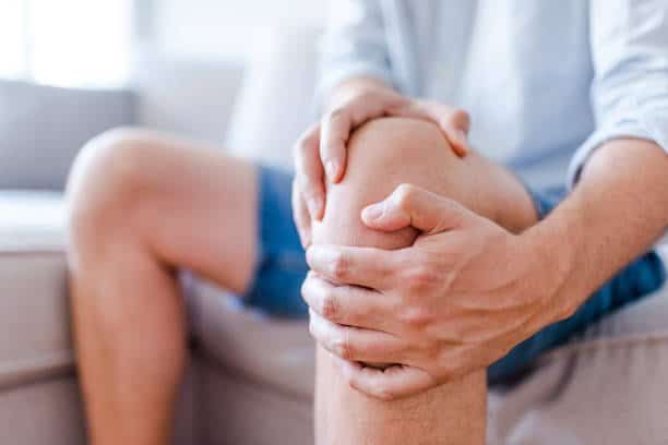 joint health: person holds knee in pain