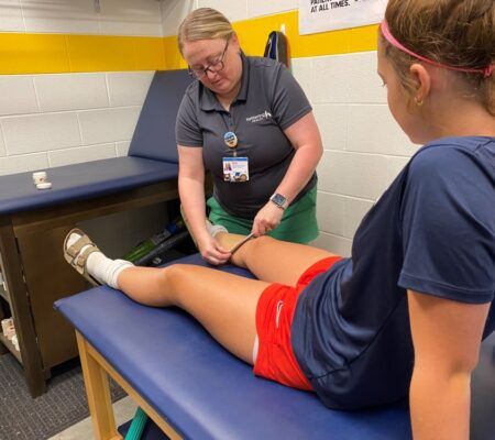 Katlie LaRue-Martin, Athletic Trainer, tends to student-athlete injury