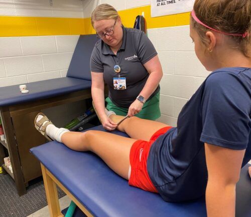 Katlie LaRue-Martin, Athletic Trainer, tends to student-athlete injury